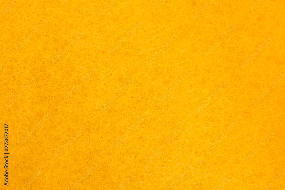 Yellow abstract background consisting of intertwined and intertwining hairs. The pattern obtained by high magnification under the microscope. Macro shot of the surface of a sponge for washing dishes. Yellow abstract background consisting of intertwined and intertwining hairs. The pattern obtained by high magnification under the microscope. Macro shot of the surface of a sponge for washing dishes.