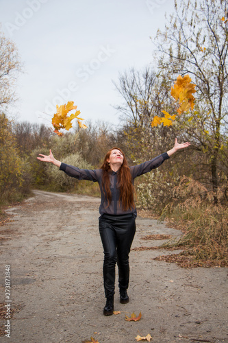 young redhead woman in autumn park. autumn yellow leaves
