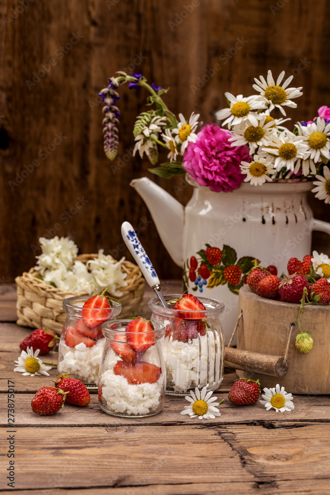 strawberry with cream cheese in glass jars, healthy summer food in a rustic style