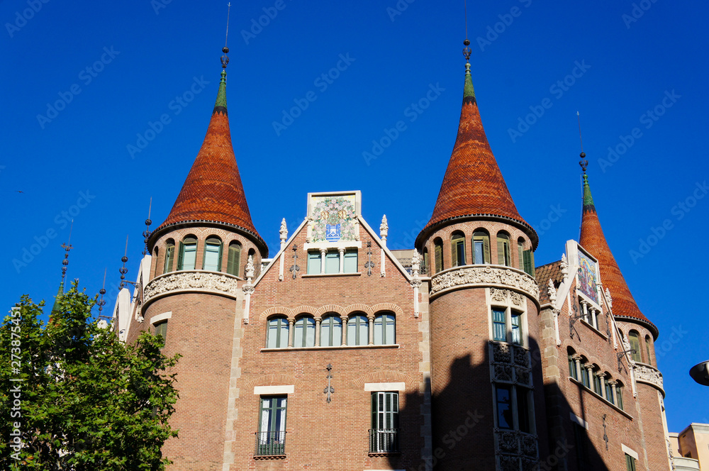 Modernists building in Barcelona. Decorative elements on the facade of the house. Brown bricks and blue sky. summertime
