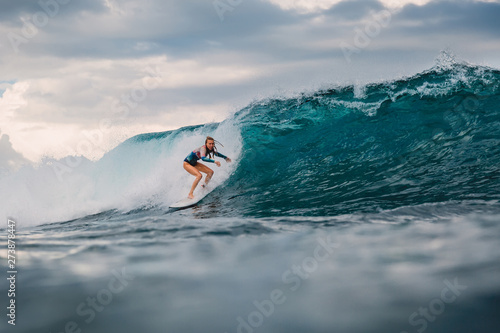 Surf girl on surfboard. Surfer woman and big blue wave © artifirsov