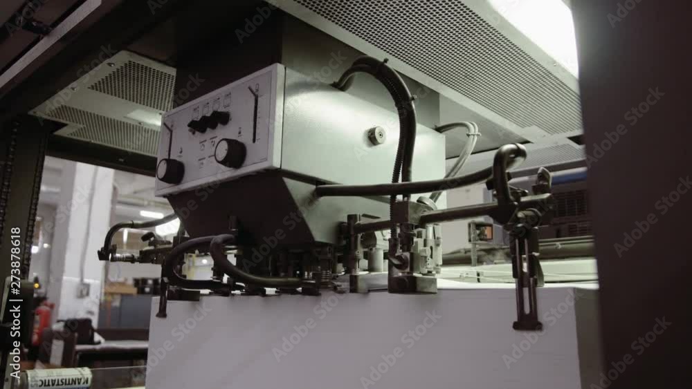 Printed sheet of paper coming out from printing machine. Offset printing, CMYK, close up Printed sheet of paper coming out from printing machine. Offset printing, CMYK, close up