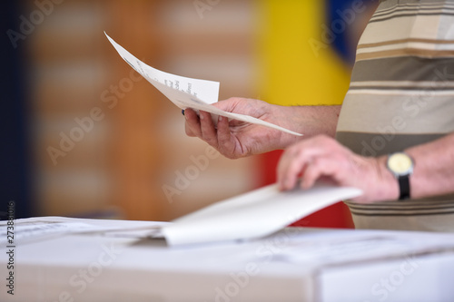 Person casting a vote into the ballot box during elections