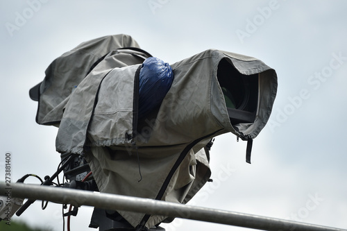 Television broadcast camera setup on a tripod and protected by a rain cover