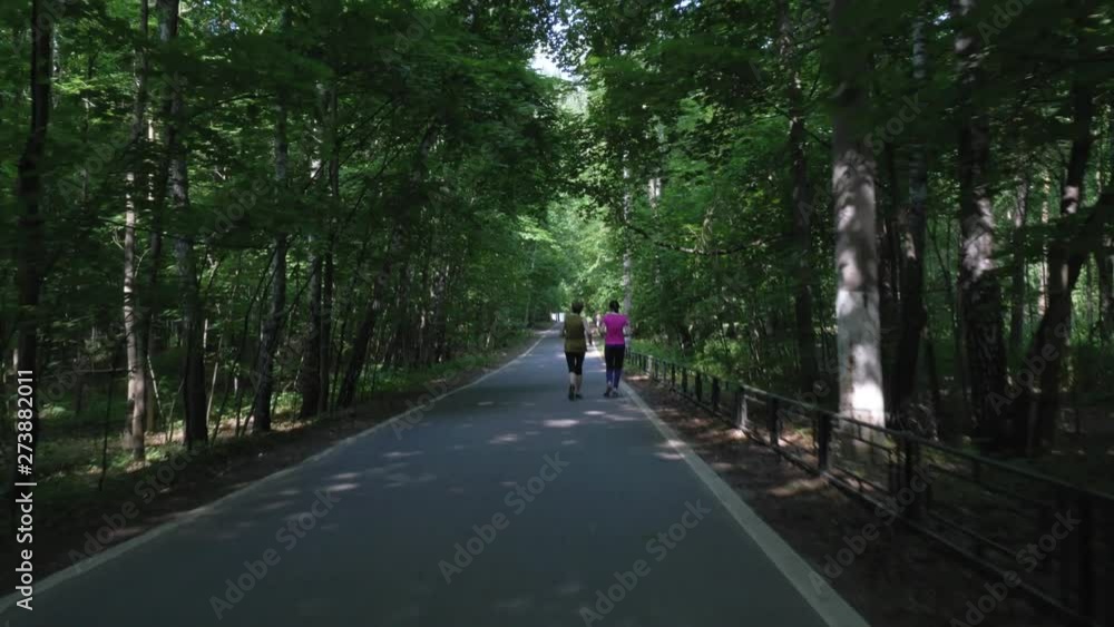 cycle rides along bicycle lane and follows running women cycle rides along bicycle lane and follows running women