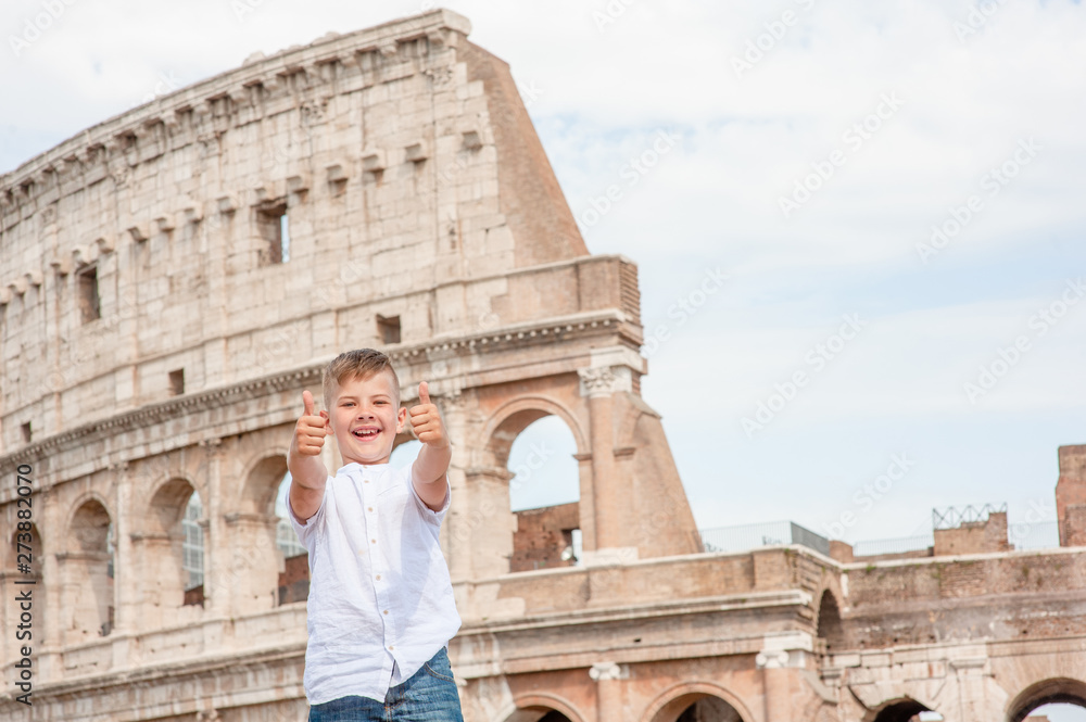 Happy boy showing thumbs up at the coliseum in rome, Italy. Travel concept. Space for text