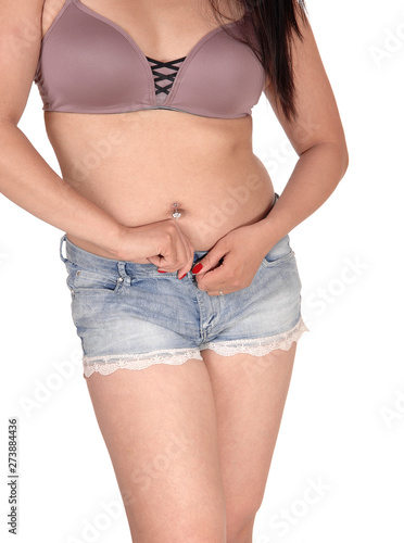 Woman standing from front opening her shorts buttons