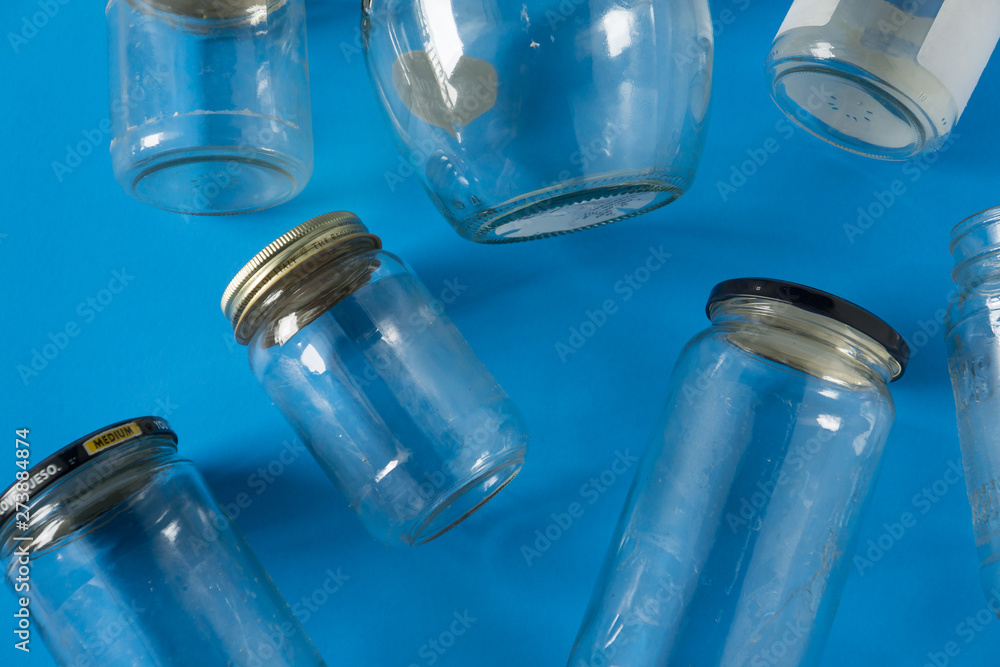 Glass jars with lids on blue background, top view flat lay recycling concept Glass jars with lids on blue background, top view flat lay recycling concept