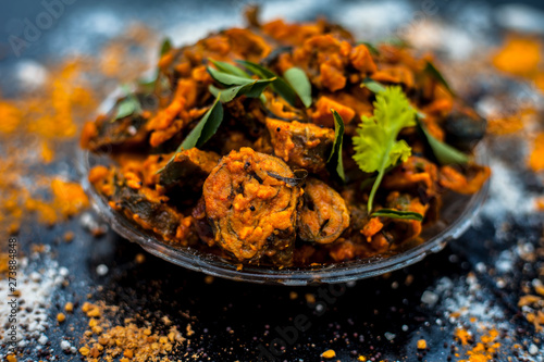 Famous Indian & Gujarati snack dish in a glass plate on wooden surface i.e. Patra or paatra consisting of mainly Colocasia esculenta or arbi ke pan or elephant ear leaves and spices. Horizontal shot. photo