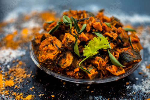 Famous Indian & Gujarati snack dish in a glass plate on wooden surface i.e. Patra or paatra consisting of mainly Colocasia esculenta or arbi ke pan or elephant ear leaves and spices. Horizontal shot. photo