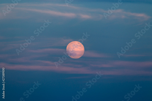 Full moon with colorful skies at sunset
