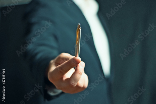 Businessman offering a silver pen 