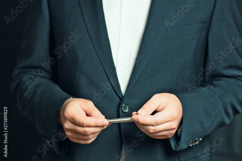 Businessman holding a silver pen  while explaining or presenting