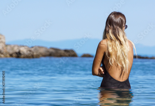 Close up portrait of beautiful young woman on the beach. Young caucasian female model on the sea shore. © steuccio79