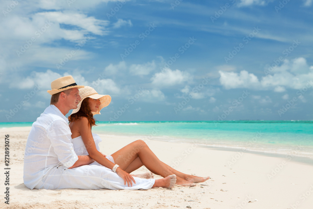Happy honeymoon vacation at summer. Couple relax on the white sand of beach. Happy sea lifestyle. Young family, man and woman rest on the beach of ocean. Couple in love travel to island. Love travel Happy honeymoon vacation at summer. Couple relax on the white sand of beach. Happy sea lifestyle. Young family, man and woman rest on the beach of ocean. Couple in love travel to island. Love travel