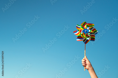 Child holds colorful pinwheel