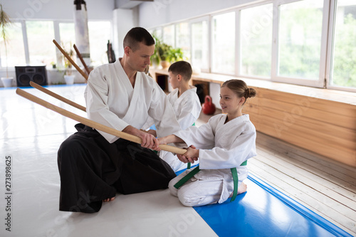 Professional aikido trainer working with little blonde girl