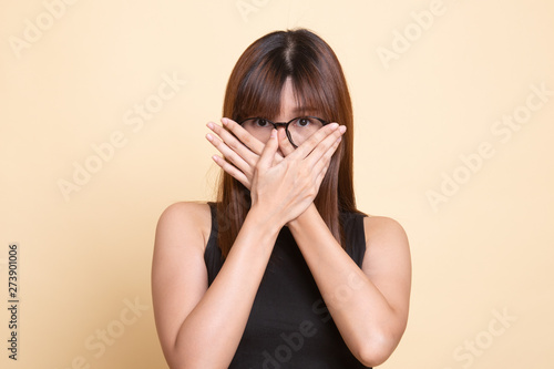 Beautiful young Asian woman close her mouth.