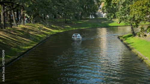 Small river channel ferry transporting tourists in Riga city center in a sunny summer weekend