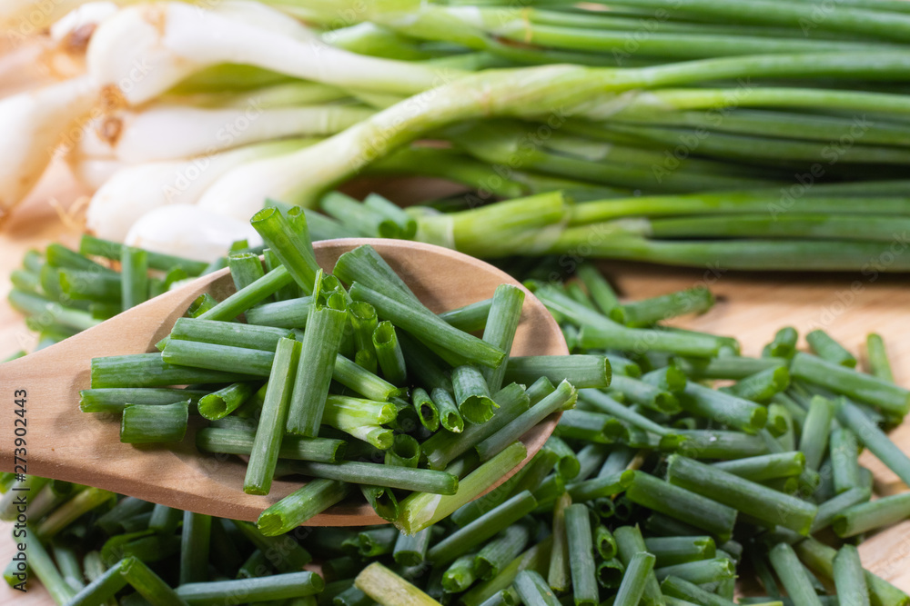 chopped of fresh scallion or spring onions on wooden board chopped of fresh scallion or spring onions on wooden board