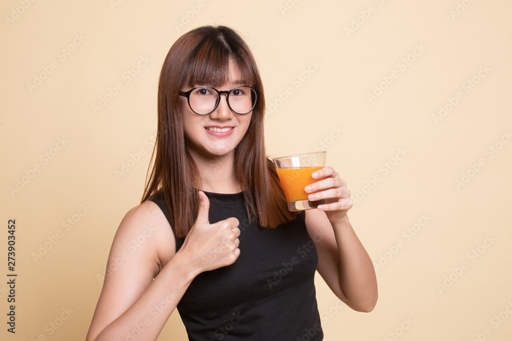 Young Asian woman thumbs up drink orange juice. Young Asian woman thumbs up drink orange juice.