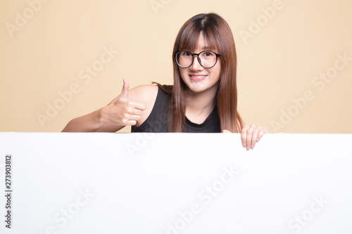 Young Asian woman show thumbs up with blank sign.