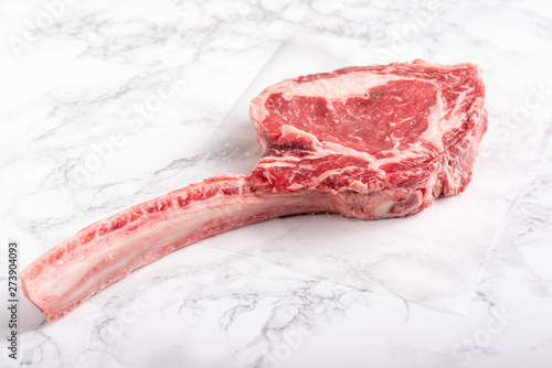 tomahawk ribeye steak on marble background