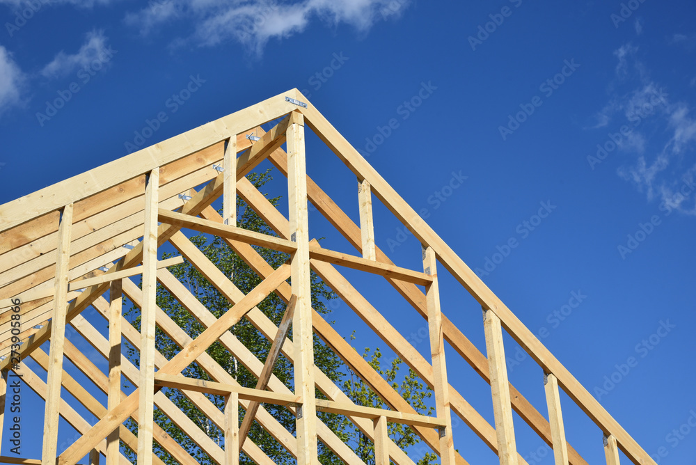 Obraz premium Wood frame residential building under construction.Building construction, wood framing structure at new property development site.new home currently under construction against blue sky.mortgage, loan.