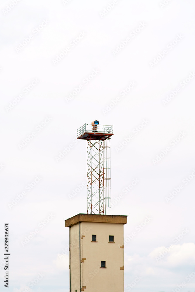 Ein stillgelegter Wachturm mit einem Flutlicht auf einem stillgelegten Flughafengelände. .. Ein stillgelegter Wachturm mit einem Flutlicht auf einem stillgelegten Flughafengelände. ..