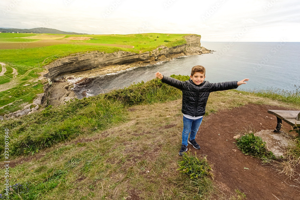 Winning and euphoric child with a cliffs background