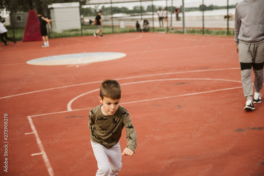 Fototapeta premium A little boy on a basketball court
