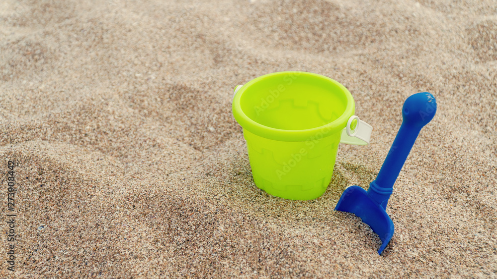 Plastic children's toys in the sand. Concept of family vacation. Top view. Space for text. Plastic children's toys in the sand. Concept of family vacation. Top view. Space for text.