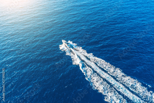 Boat launch at high speed floats to sunlight in the Mediterranean, aerial top view. © aapsky