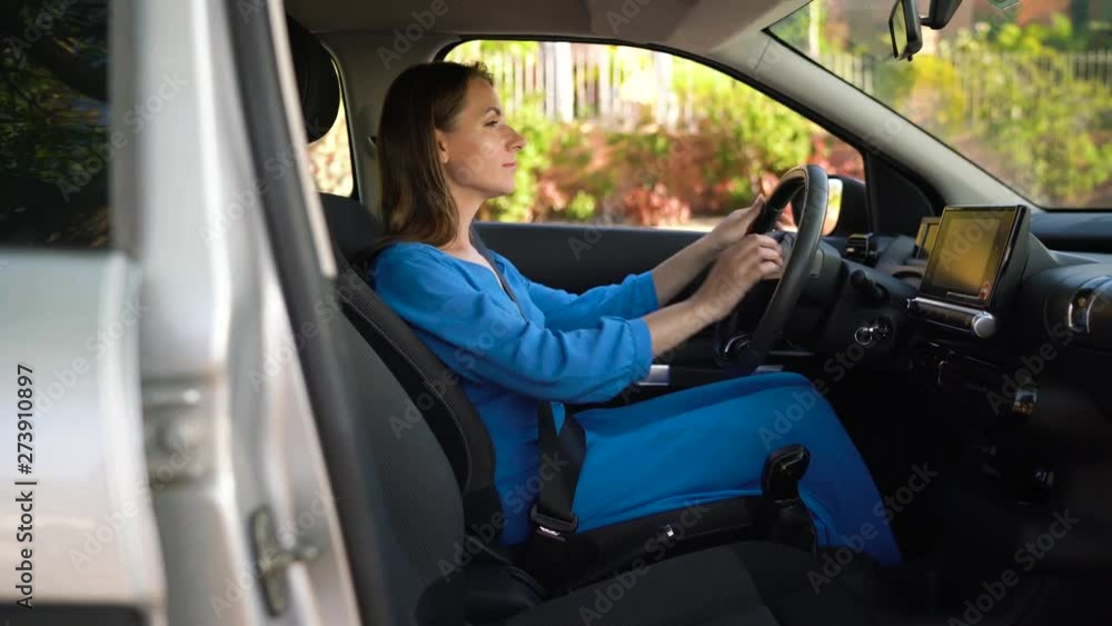 Woman fastening car safety seat belt while sitting inside of vehicle before driving Woman fastening car safety seat belt while sitting inside of vehicle before driving