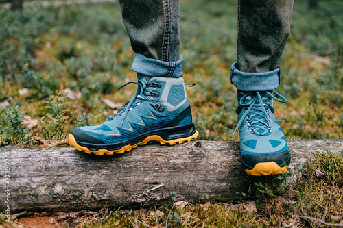 Male legs wearing sportive hiking shoes outdoor. Mens legs in trekking boots for outdoor activity