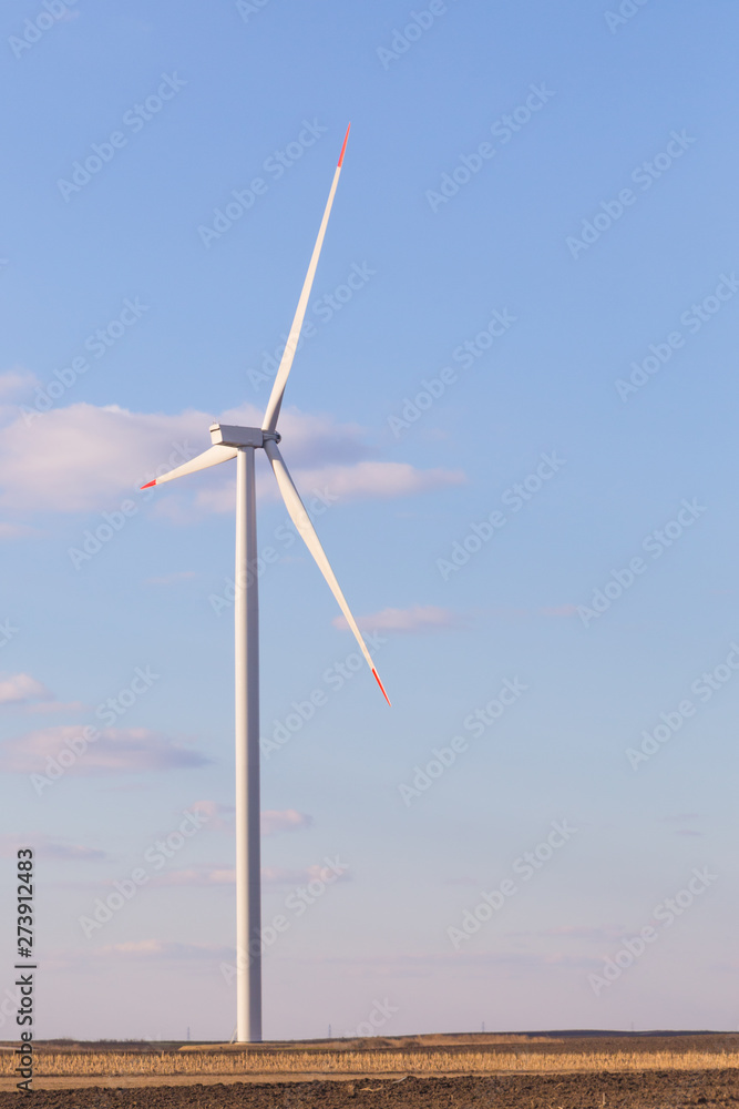 One wind turbine with cloudy sky in background