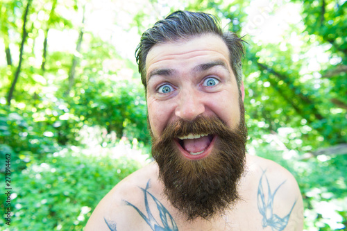 Summer madness. Man cheerful bearded hipster taking selfie in wild nature. Guy crazy emotional face surviving in hot forest. Summer vacation concept. Having fun. Blogger summer natural environment