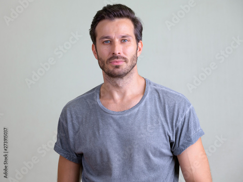 Studio shot of handsome bearded man looking at camera