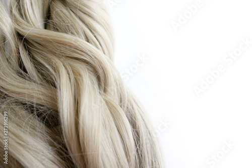 Beautiful wavy hair. Light brown hair. Hair is gathered in a bun on a white background. With free space for text. For a poster or business card.