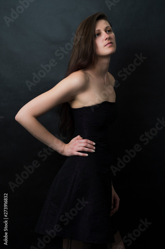 Studio portrait of the beautiful women on the black background with a cold blue tint. Gorgeous Women posing in a studio. Magic and mysterious concept.