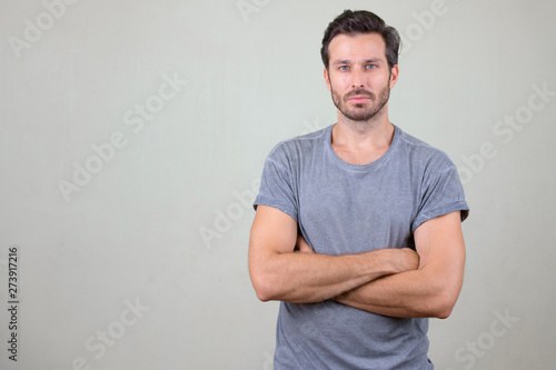 Studio shot of handsome bearded man with arms crossed photo