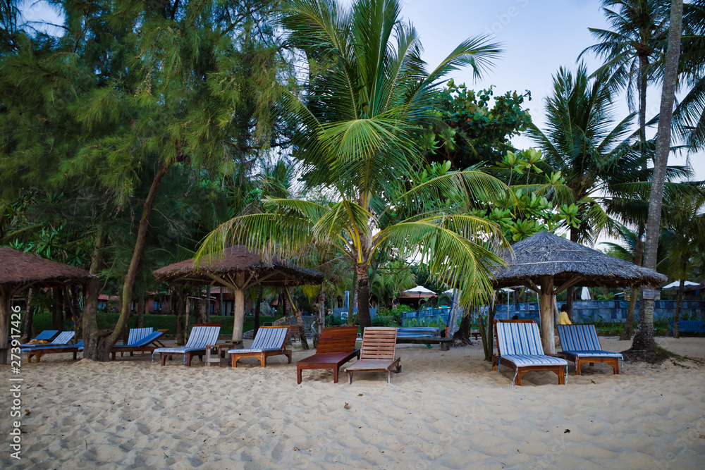 Phu Quoc island, Vietnam - March 30, 2019: Cozy hotel beach area in the evening. Straw umbrellas
