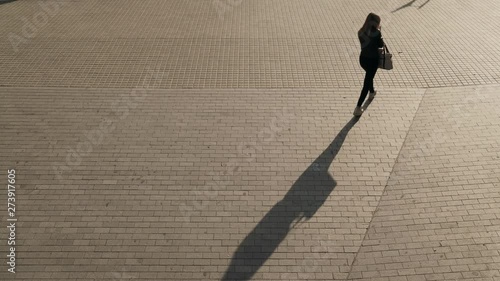 Monochrome shadows moving from the metro. People walking silhouette in the morning light. Early hours in the city. Urban movements and creative background. Bricks on the street of Barcelona
