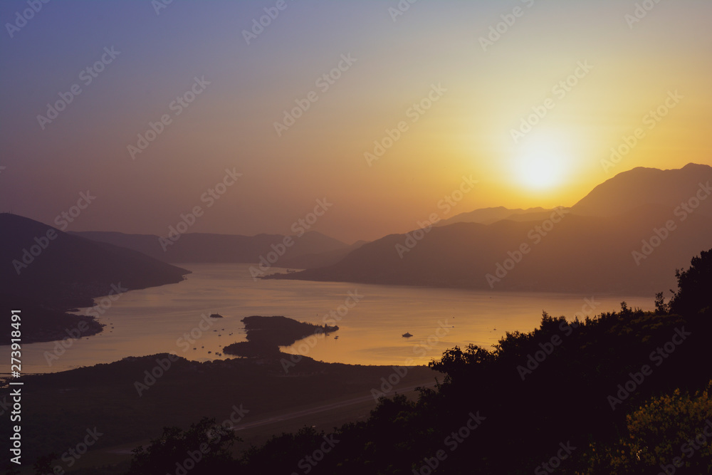 Sunset behind the mountains against the backdrop of the sea Sunset behind the mountains against the backdrop of the sea