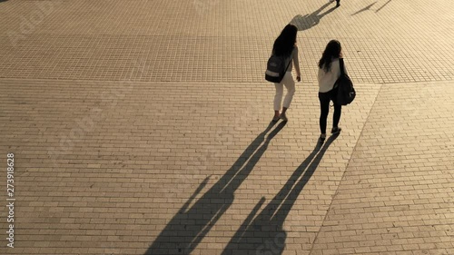 Monochrome shadows moving from the metro. People walking silhouette in the morning light. Early hours in the city. Urban movements and creative background. Bricks on the street of Barcelona