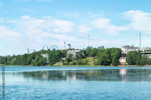 Toolo Bay in City Park, Helsinki, Finland. Across the water, rides at Linnamaki amusement park can be seen above the trees.