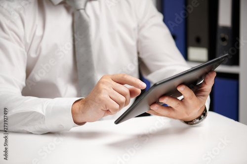 Businessman working with tablet pc, calculating, reading and writing reports. Office employee, table closeup. Business financial accounting concept.