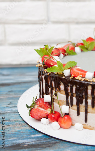 A part of cake with strawberries, cherries, marshmallows with chocolate droplets. Free space for writing photo