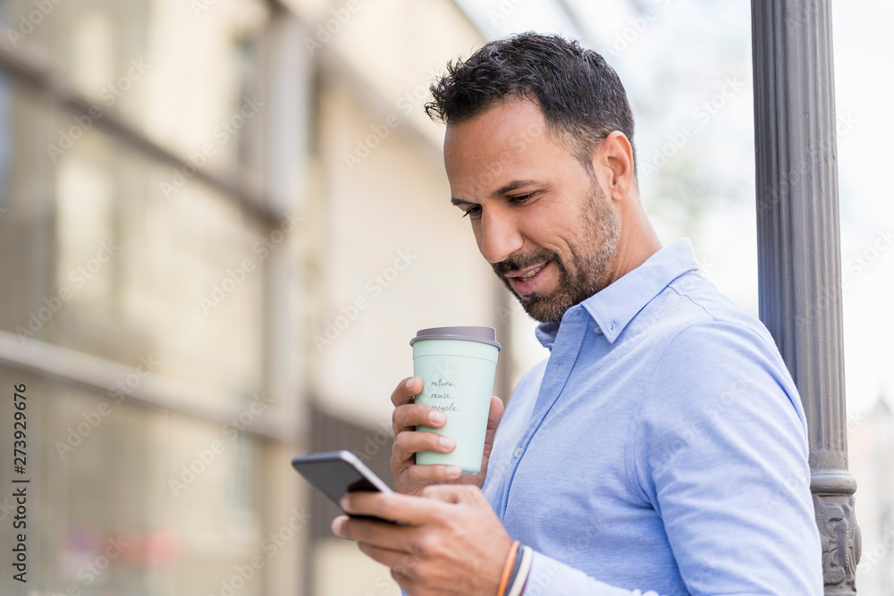 Businessman with takeaway coffee and cell phone in the city Businessman with takeaway coffee and cell phone in the city