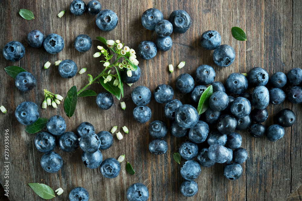 Blueberries and blueberry blossoms on wood Blueberries and blueberry blossoms on wood